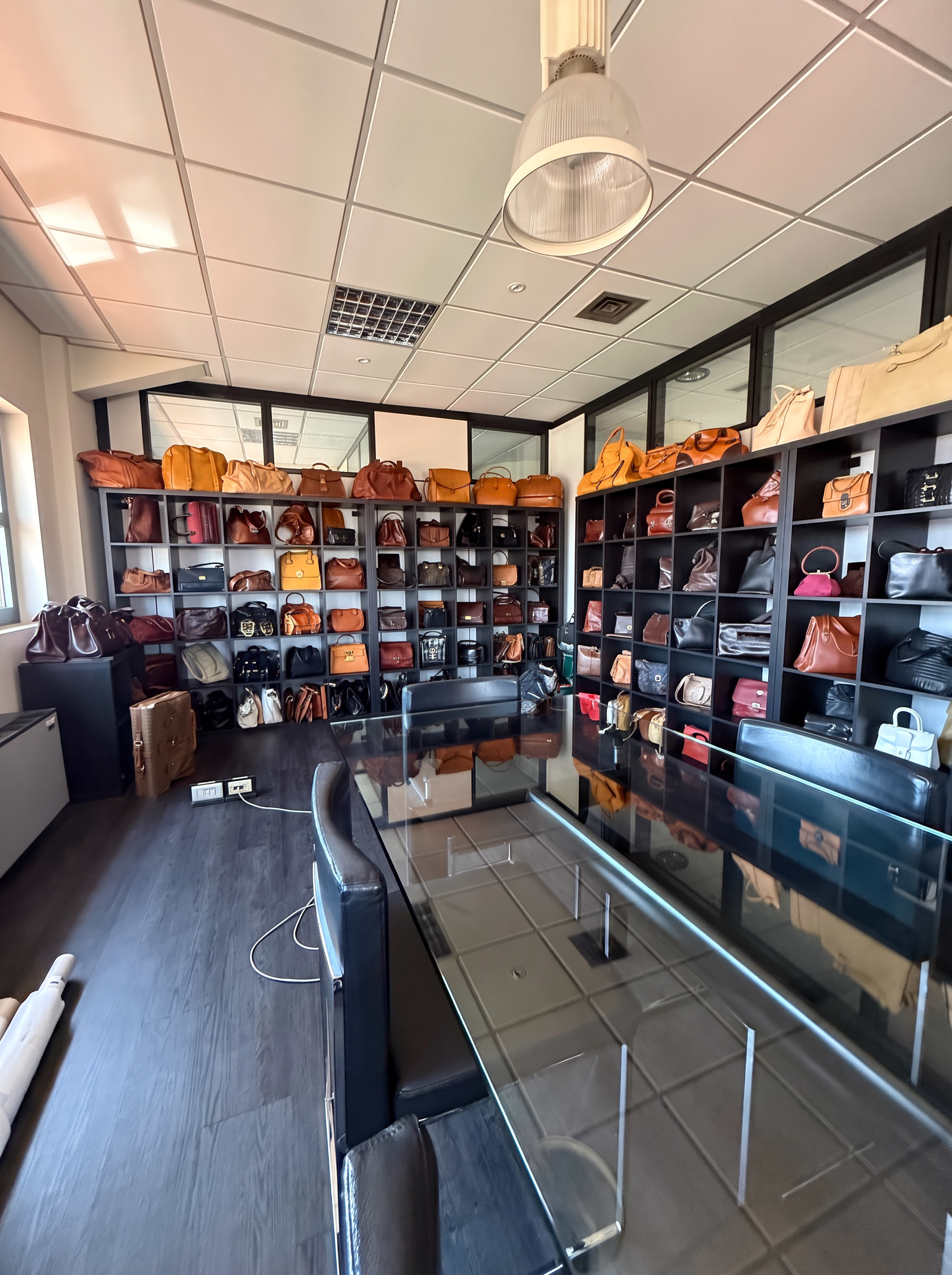Archivio vintage AMA Milano con borse storiche esposte su scaffali